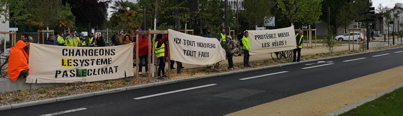 image des banderoles “ici tout nouveau tout faux”, “protégez mieux les vélos”, et “changeons le système pas le climat”